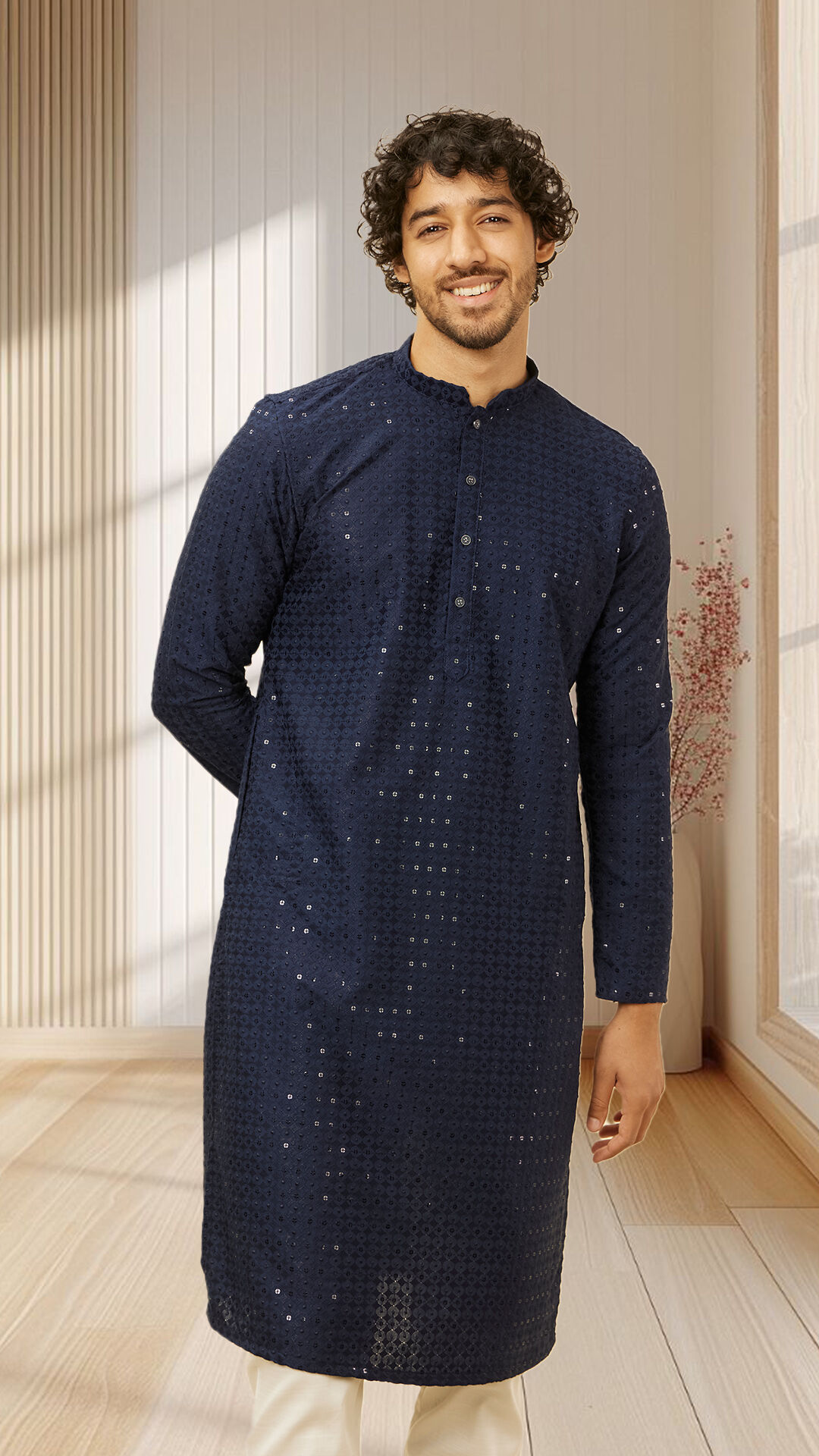 Man in navy blue Chikankari kurta posing indoors, ideal groom outfit inspiration